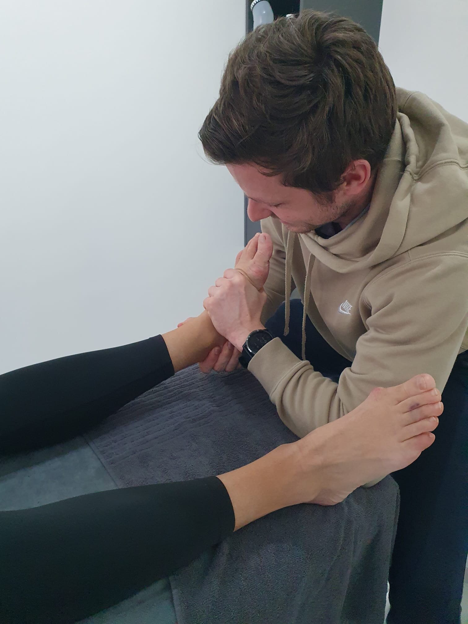 Een persoon met sportkleren aan die loopt op een indoor track piste.